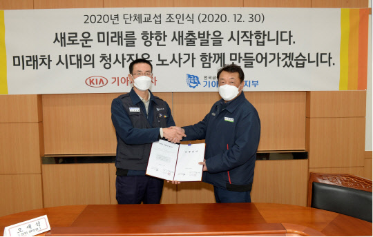 최준영(오른쪽) 기아차 대표이사와 최종태 노조위원장이 30일 경기도 광명시 소하리공장에서 2020년 단체교섭 조인식을 마친 뒤 악수하고 있다.<기아자동차 제공>